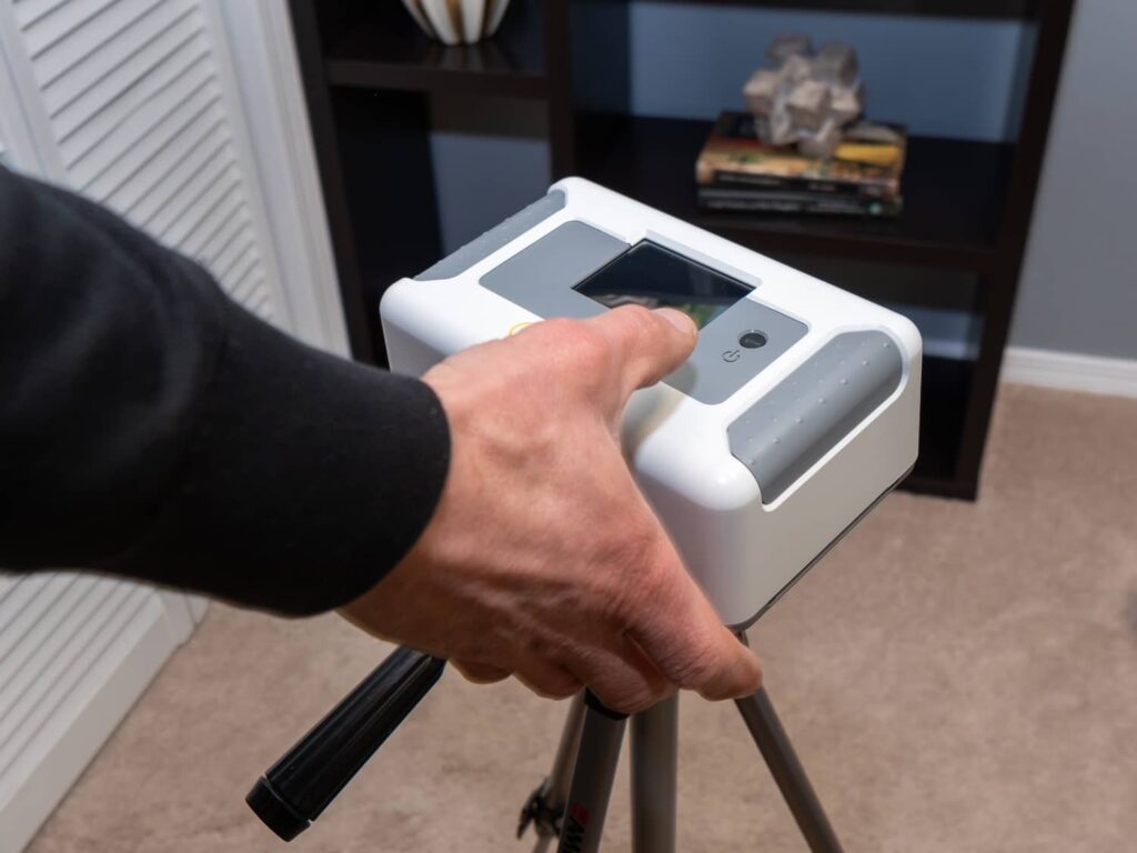A home inspector setting up a continuous radon monitor inside a home